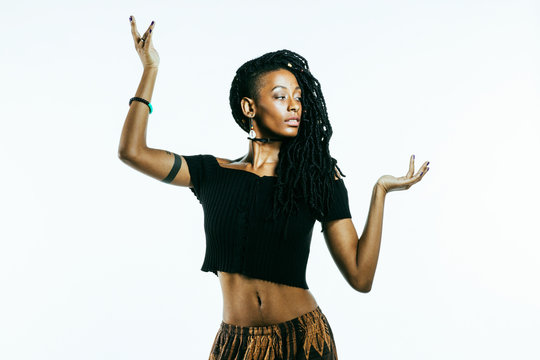 African American woman with dreadlocks with arms up in a dancing  pose  and belly button