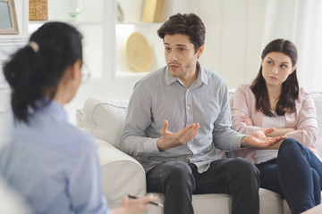 Young man explaining himself to family therapist