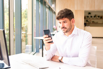 Young businessman text messaging in the office