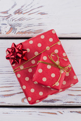 Gift boxes wrapped in red dotted paper. Polka dot red present boxes on wooden background. Fashion gifts packaging.