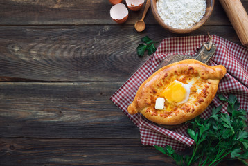 Khachapuri Ajarian on rustic wooden background