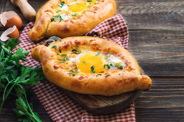 Khachapuri Ajarian on rustic wooden background