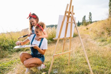 family, children and people concept - happy mother and daughter drawing and talking over green background. Mother's Day