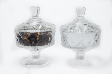 empty glass jar and jar containing dates on white background