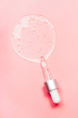 Face serum close-up on the trendy coral background. Collagen, hyaluronic acid for skin care....