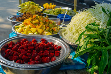 Bowls of brightly coloured tropical fruit on a street cart in Mandalay, Myanmar