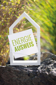 Wei&szlig;es Haus vor nat&uuml;rlichen Hintergrund mit Schild Energieausweis