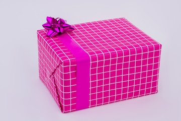 Beautiful big gift box with satin ribbon. Pink checkered present box with bow. Birthday gift background.