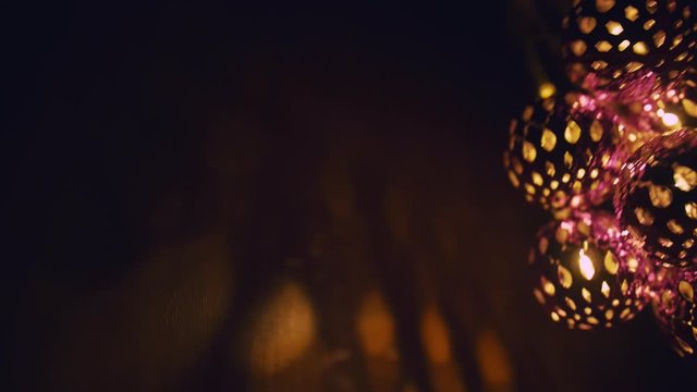 Magic lanterns spin and give beautiful glare to the walls. New Year glowing balls with led diodes are held in hands. Warm lamp light gives cosiness and christmas mood.