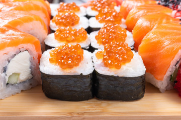 Sushi set of rolls and poppies, with salmon and caviar. Close-up.