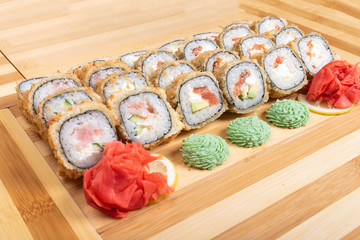 Set of baked rolls with various fillings. Close up with ginger and wasabi.