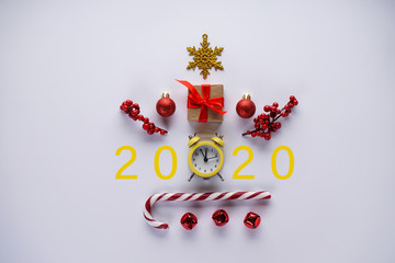 New Year celebration time 2020. Christmas decoration and yellow vintage alarm clock on a gray background. Christmas clock.