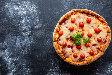 Delicious bright pizza on a dark background