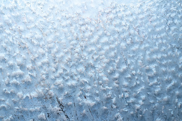 Obraz premium Surface of a winter frozen window is backlit by the sun outside, background, texture
