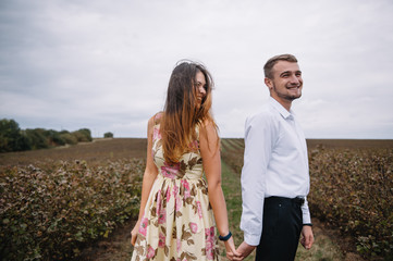 A girl and a guy are walking in the nature. Portrait of a couple, a love story.Happy smiling, loveing couple together outstretched at beautiful nature. Lovestory