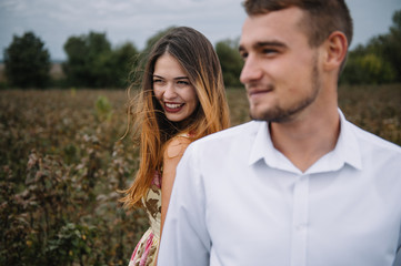 A girl and a guy are walking in the nature. Portrait of a couple, a love story.Happy smiling, loveing couple together outstretched at beautiful nature. Lovestory