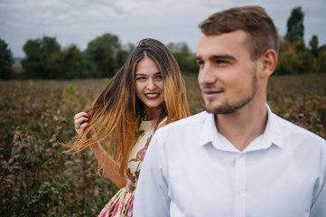 Obraz premium A girl and a guy are walking in the nature. Portrait of a couple, a love story.Happy smiling, loveing couple together outstretched at beautiful nature. Lovestory