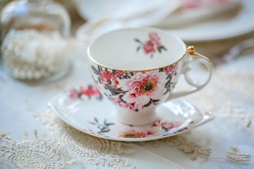 Obraz na płótnie Canvas Luxury porcelain tea set with a cup, teapot, sugar bowl on white tablecloth 