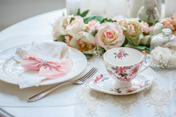 Fototapeta na wymiar Luxury porcelain tea set with a cup, teapot, sugar bowl on white tablecloth 