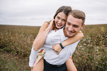 Obraz premium A girl and a guy are walking in the nature. Portrait of a couple, a love story.Happy smiling, loveing couple together outstretched at beautiful nature. Lovestory