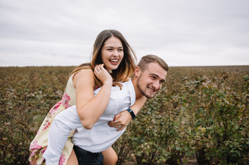 A girl and a guy are walking in the nature. Portrait of a couple, a love story.Happy smiling, loveing couple together outstretched at beautiful nature. Lovestory