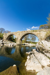 Obraz premium Beautiful old stone arch bridge over river.