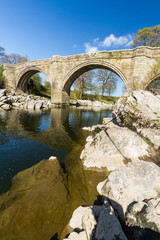 Obraz premium Beautiful old stone arch bridge over river.