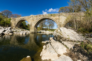 Beautiful old stone arch bridge over river.