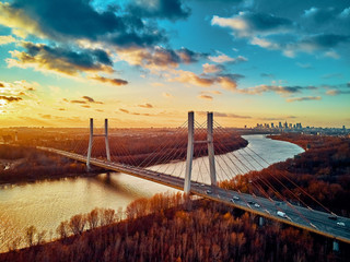 Fototapety  Piękny panoramiczny widok z lotu ptaka na most Siekierkowski nad Wisłą i wieżowce Warsaw City, Polska w złoto-czerwonych kolorach jesieni w listopadowy wieczór o zachodzie słońca