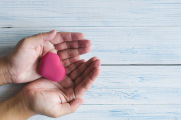 pink heart shaped bubble in Asian man palm in pastel color tone view from the top