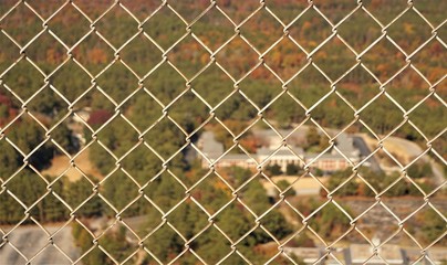 Top view image of landscape looking through the white metal net fence from the top of the stone mountain in Autumn , Atlanta ,GA USA.