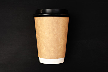 Paper coffee cup on black background. Mock up mug