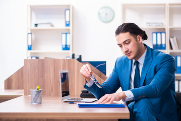 Fototapeta premium Young handsome businessman sitting in the office