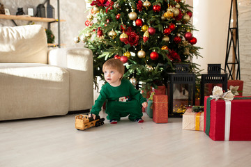 Christmas, holidays and childhood concept - smiling boy with gift box at home