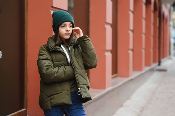 stylish teen girl outdoors in a hat and jacket