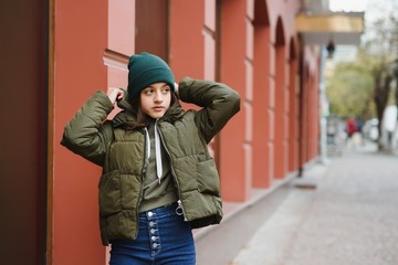 stylish teen girl outdoors in a hat and jacket