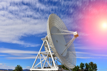 Array of satellite dishes or radio antennas against sky. Space o