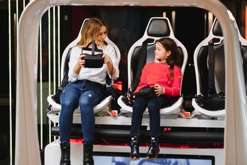 Fototapeta na wymiar family, technology and virtual reality concept - mother and daughter in vr glasses