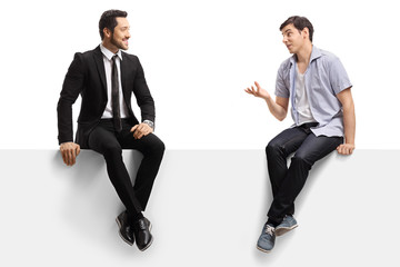 Businessman and a young man sitting on a panel and talking