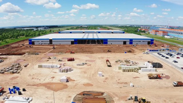 aerial motion above construction site to storage building