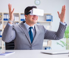 Businessman with virtual reality glasses in modern technology co