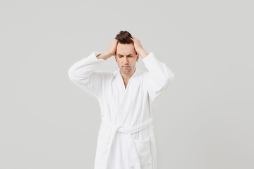 Sleepy man in bathrobe on grey background