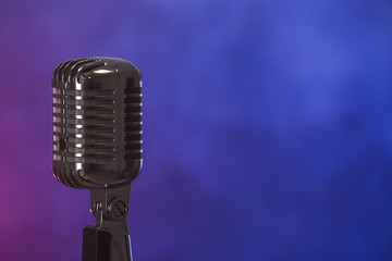 Fototapeta na wymiar Retro microphone on dark color background with smoke