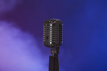 Retro microphone on dark color background with smoke