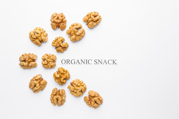 Tasty walnuts with text ORGANIC SNACK on white background