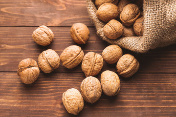 Sack with tasty walnuts on wooden table