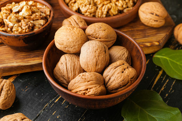 Bowl with tasty walnuts on wooden table