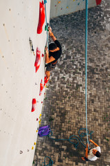Fototapeta na wymiar Muscular man climbing on a big wall