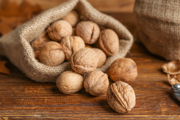Sack with tasty walnuts on wooden table