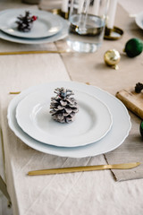 Christmas and New Year table setting in scandinavian style with rustic handmade details in natural and white tones.